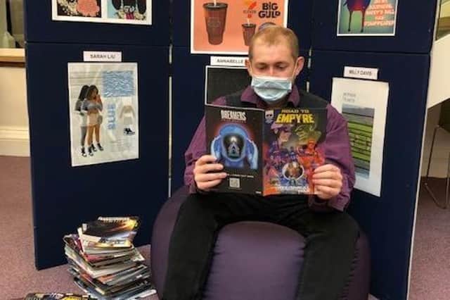 Library assistant Tom Bamford sampling one of the free comics
