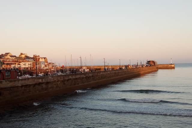 The sun’s rays give the harbour wall an orange tinge in this photo by Brigid Hutchinson.