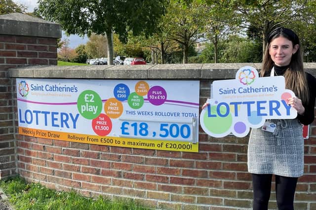 Saint Catherine’s Hospice fundraiser Ellie Fry is pictured with the charity’s lottery sign.