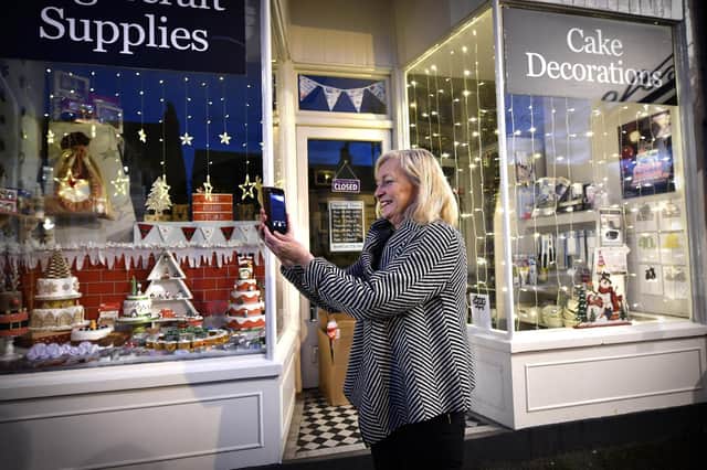Jo Pickard takes a picture outside the Icing Store which has really gone to town in the first Christmas window display in Falsgrave