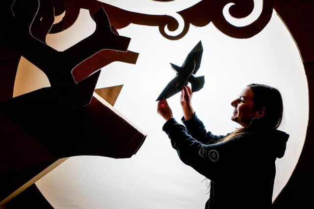 The installation creates illuminated scenes using just recycled cardboard.