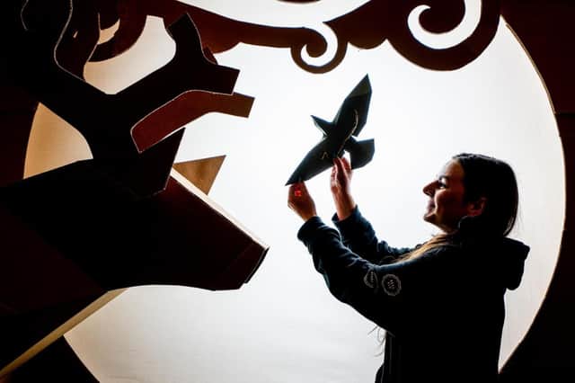 The installation creates illuminated scenes using just recycled cardboard.