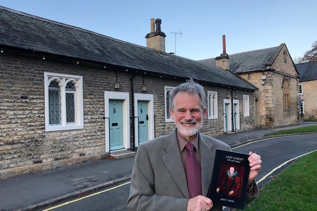 Historian and author John Smith with his book outside the almshouses in Thornton Dale which were founded by Lady Eliza Lumley