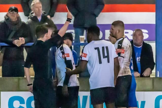 Grantham Town's Glenn Yala is shown a red card for a challenge on Whitby Town player Malik Dijksteel.