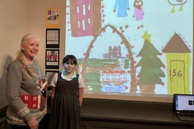 Mayor of Whitby, Cllr Linda Wild, with Christmas card competition winner Olivia Owen-Taylor, 8, and her card projected on to a gallery wall.