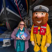 Jessica Redland at Scarborough Lifeboat Station with mascot Stormy Stan who features in her The Starfish Café series