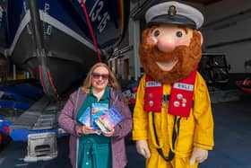 Jessica Redland at Scarborough Lifeboat Station with mascot Stormy Stan who features in her The Starfish Café series