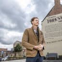 Tom Naylor-Leyland,  organiser of the Malton Food Festival, in front of the large mural of a Yorkshire pudding recipe dating from the 18th century which was created a couple of years ago on the side of  Insurance brokers McClarrons