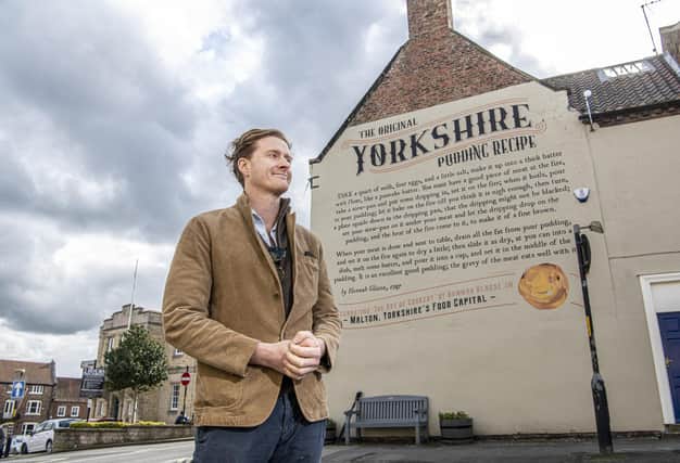 Tom Naylor-Leyland,  organiser of the Malton Food Festival, in front of the large mural of a Yorkshire pudding recipe dating from the 18th century which was created a couple of years ago on the side of  Insurance brokers McClarrons
