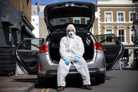 Uber driver Yasar Gorur wears personal protective equipment while cleaning his vehicle (Photo: Hollie Adams/Getty Images)