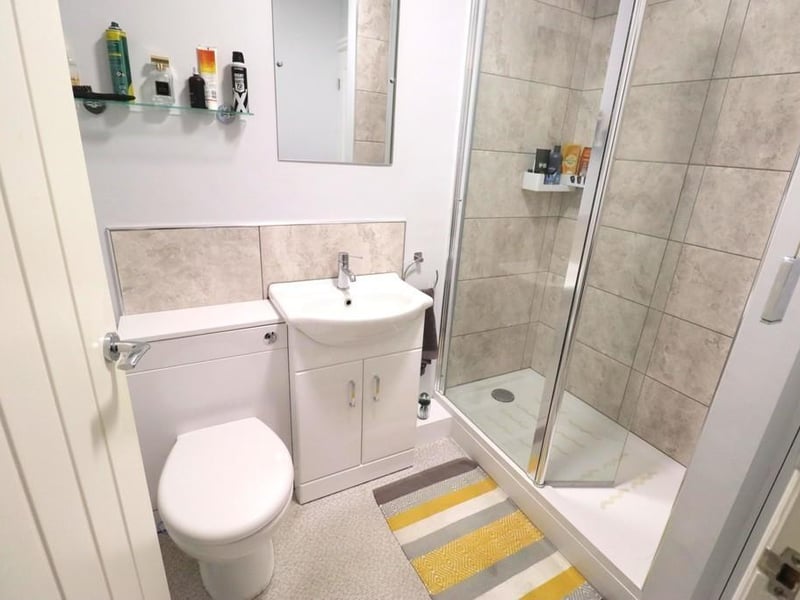 The modern shower room with thermostatic shower and wash basin vanity unit within the property.