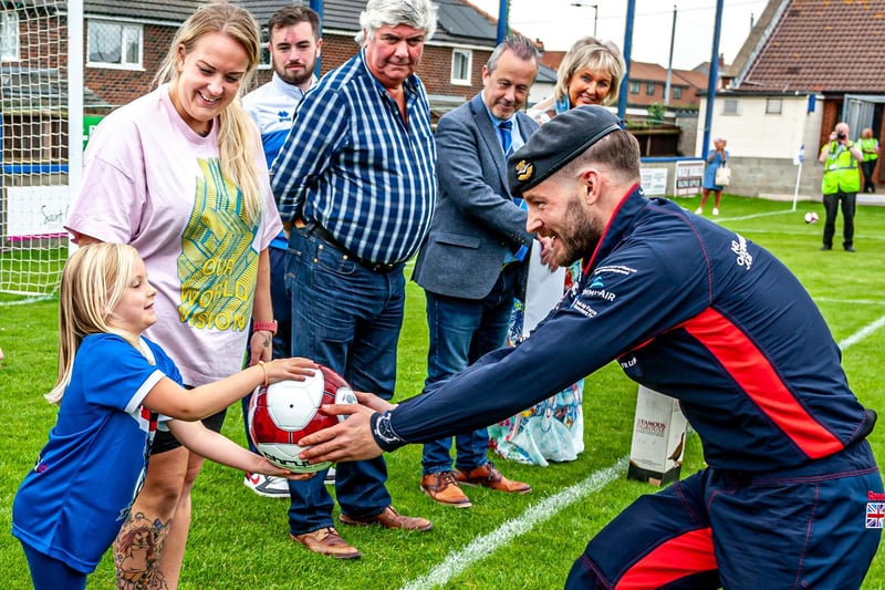 Nova Spreadbury presented with the match ball by a Falcons parachutist. She won a raffle to be presented with the ball ahead of the Whitby Town v Atherton Collieries match. 
picture: Brian Murfield