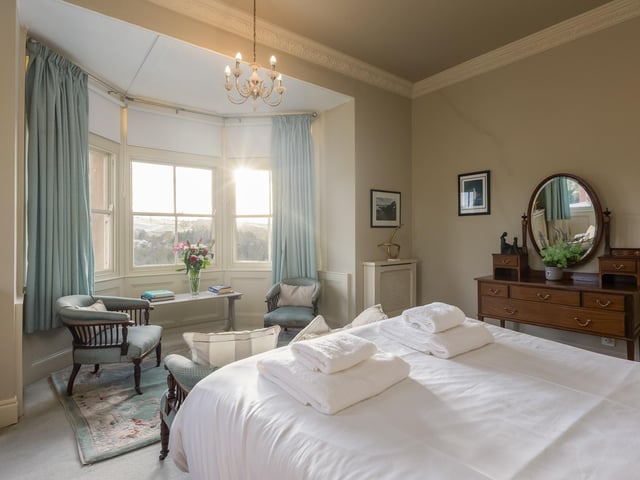 A bay-fronted bedroom looks out over the valley.