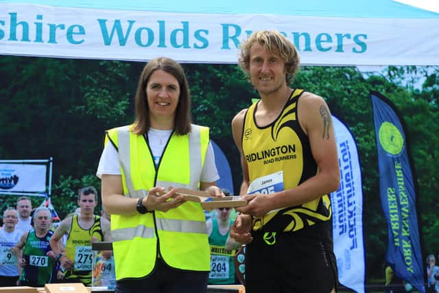 BRR athlete James Wilson receives his second-placed prize at the Top of the Wolds 10K.