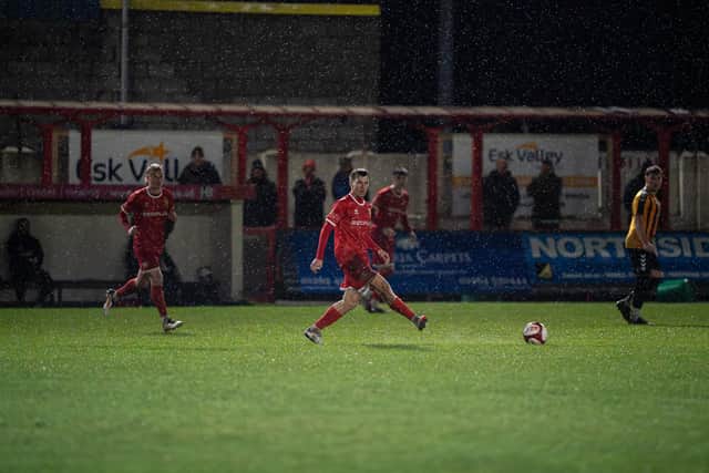 The teams battle it out in heavy rain at Queensgate. Photo by Wandering Photography