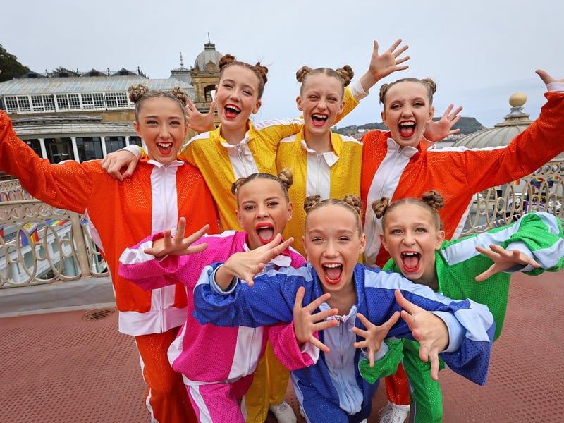 Rainbow-clad dancers at the ready