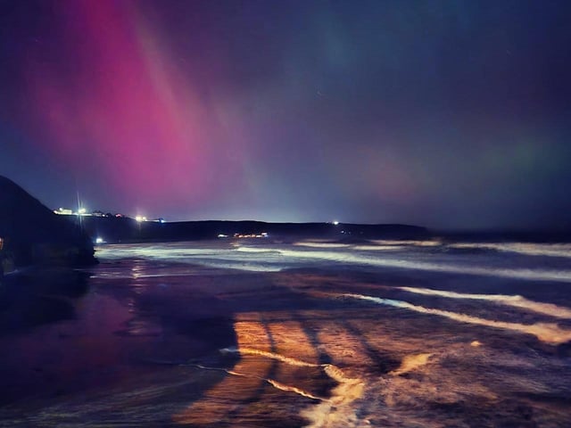 Amazing view of the Whitby beach illuminated by the Northern Lights.