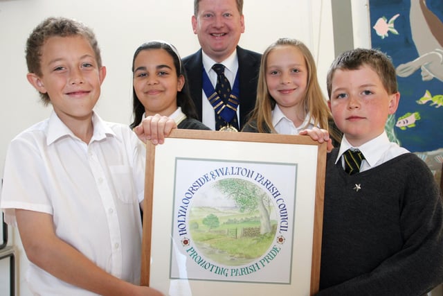 Chair of Holymoorside and Walton Parish council Martin Thacker with the children who designed the new Parish logo. Harry Witham, Andriana Vassiliou, Sophie Hopkinson and Jamie Neal.