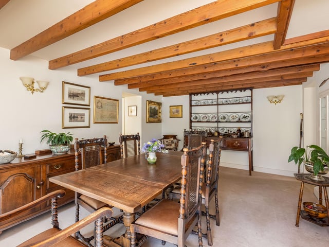 The beamed dining room has versatile space that could be put to alternative use.