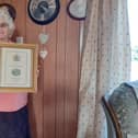 Ada Roe, who was presented with Maundy money by the Queen, pictured with a framed commemorative certificate.