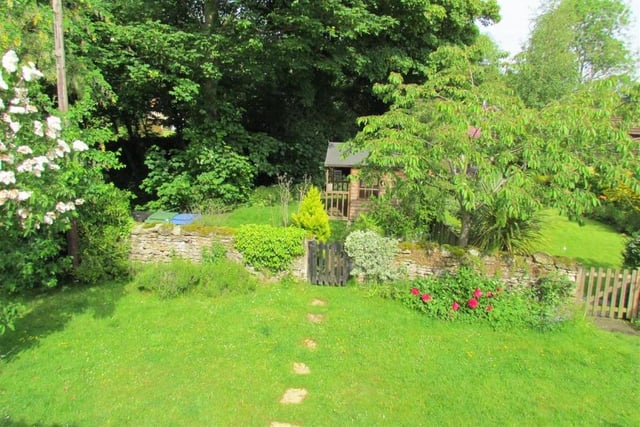 Lawned and peaceful cottage gardens with shrubs and flower borders.
