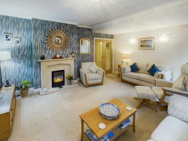 A spacious sitting room with feature fireplace.