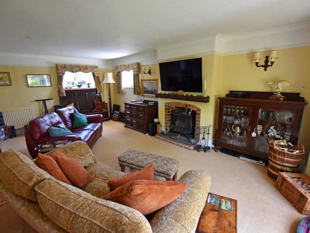 The dual aspect lounge has a central fireplace with stove.