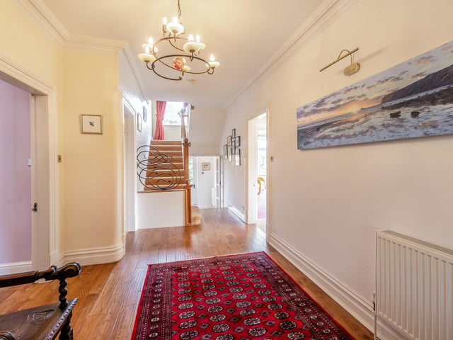 The hallway, with wooden floor, has front and rear porches with outdoor access.