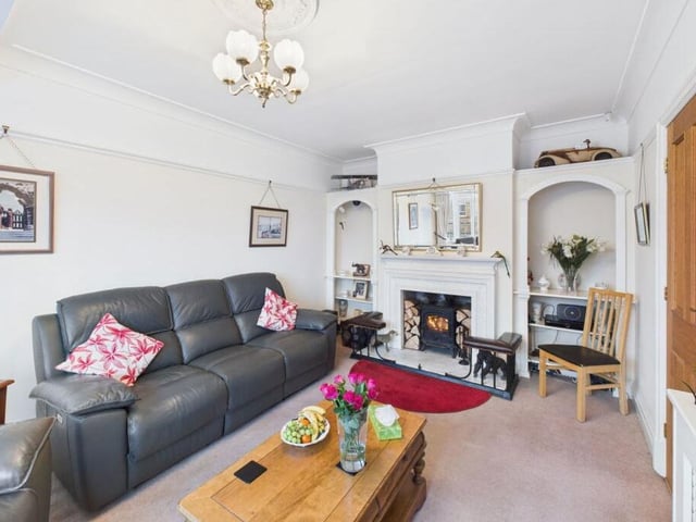 A reception room with feature fireplace and alcove shelving.