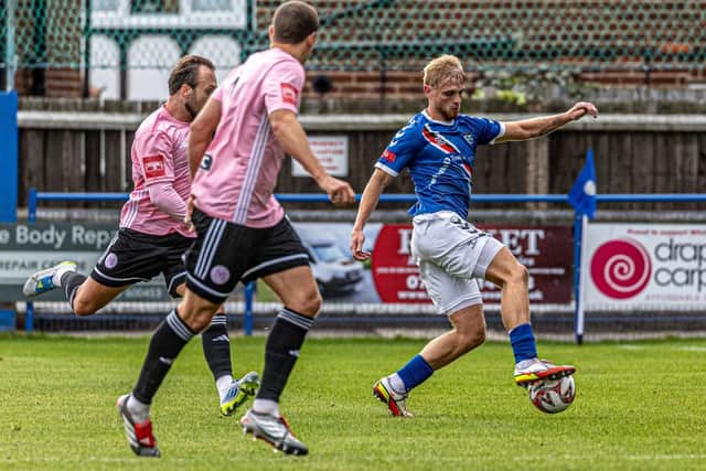 Whitby's Sam Kay shields the ball from a couple of visiting players. Photo by Brian Murfield