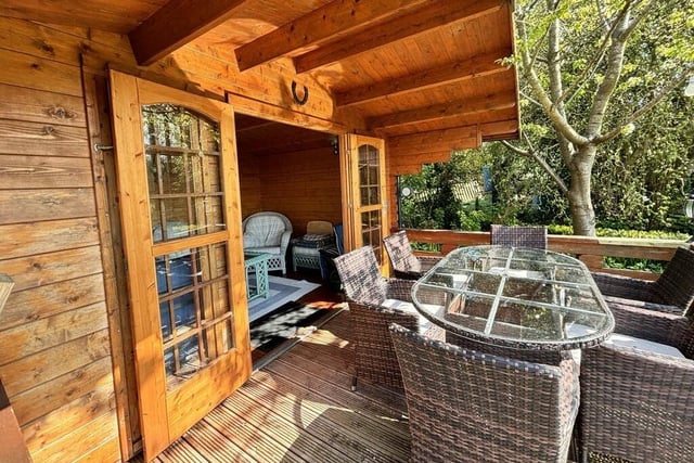 A summerhouse has a decked seating area.