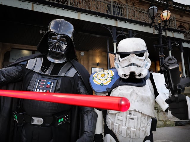 Darth Vader and a Storm Trooper draw their weapons.
