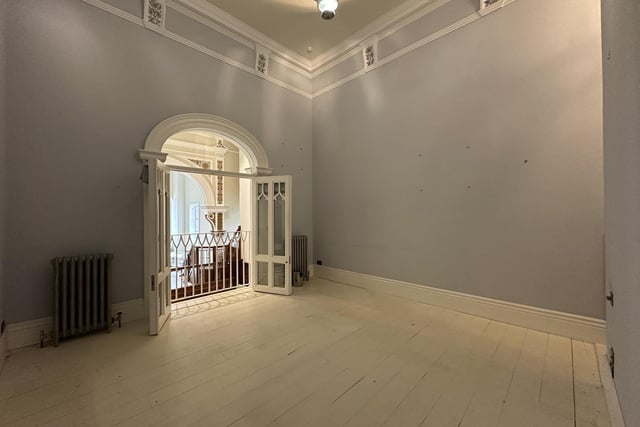Double doors open to a viewing balcony in this upper floor room within the property.