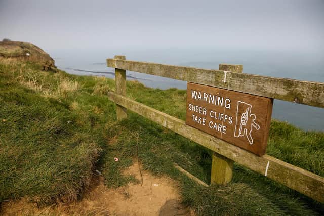 Signs on the cliff top at Filey near the Blue Dolphin Holiday Park warning of the dangers of the steep cliffs