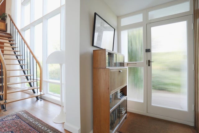 The bright reception hall with open wooden staircase leading to the first floor.