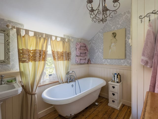 A deep, free standing bath is a feature of this appealing bathroom.