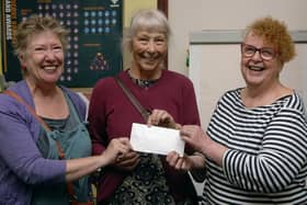 Pictured from left: Lizzie Sky Hall and Sharon Hodgson from the SJT shop presenting a cheque to Sue Wilson of the Fridge.