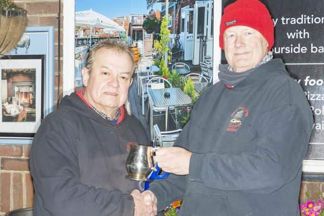 The 2025-26 Whitby Sea Anglers Association League winner Dave Perrett (left) receiving the Lord Downe Cup from Secretary Peter Horbury.