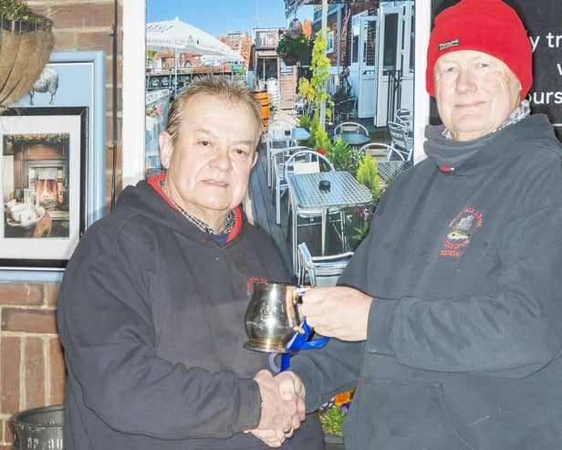 The 2025-26 Whitby Sea Anglers Association League winner Dave Perrett (left) receiving the Lord Downe Cup from Secretary Peter Horbury.