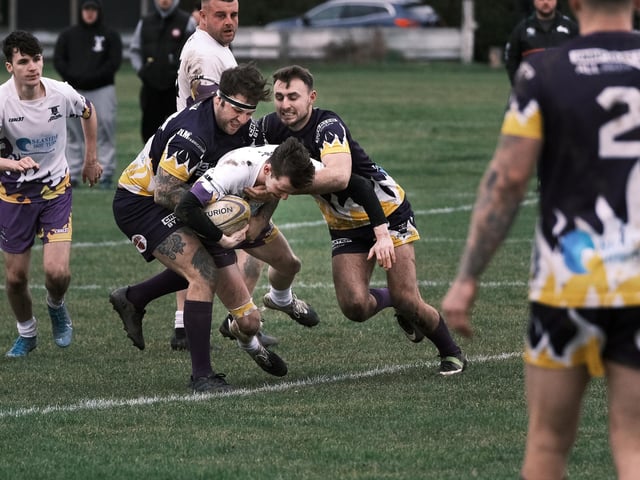 A couple of Old Boys make sure the Pirates player is halted in his tracks