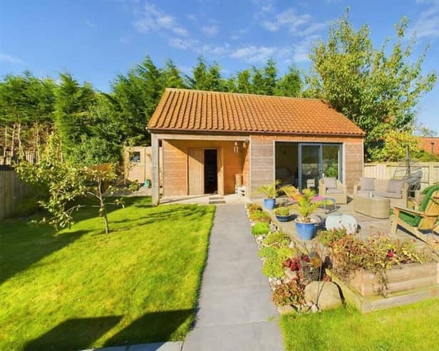 The property has a stunning rear garden with a spacious and versatile summer house.