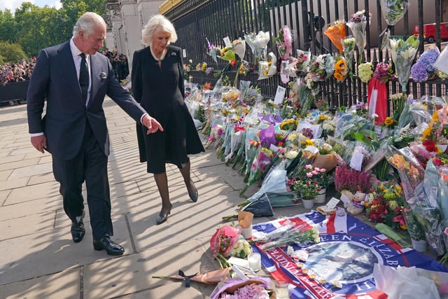 King Charles III and Camilla, Queen Consort view tributes left outside Buckingham Palace, London, following the death of Queen Elizabeth II. (Photo Yui Mok - WPA Pool/Getty Images)