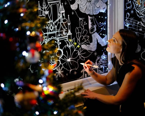 Alyssa Spivey works on her Christmas window art (Credit: Richard Ponter)