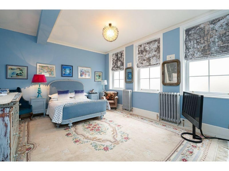 A blue bedroom, with beamed ceiling.