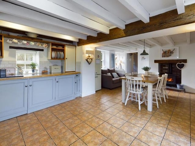 A log burner is a warming feature at one end of the kitchen with diner.