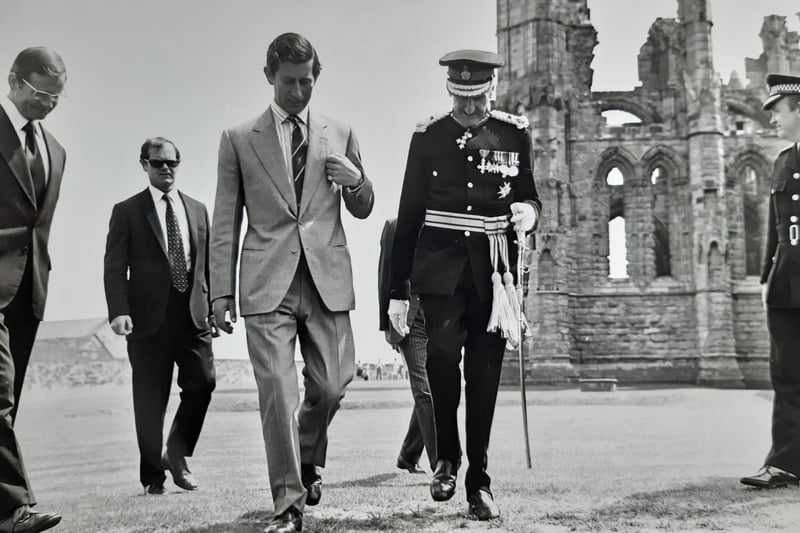 Prince Charles walks through Whitby Abbey grounds.