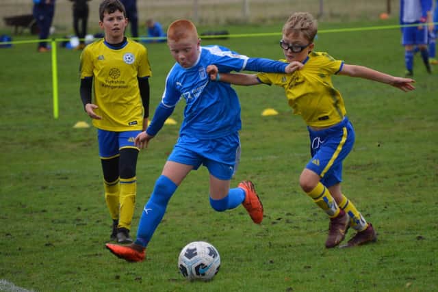 Hosts Heslerton Under-11s (blue) pull away from Seamer Under-11s