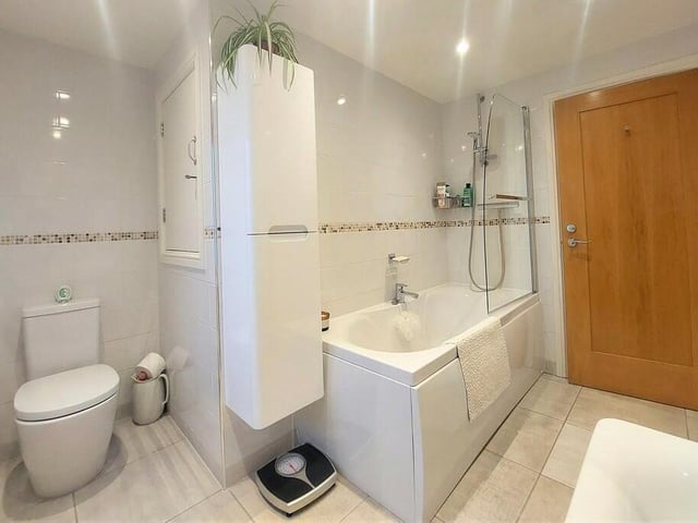 The spacious house bathroom with bath and overhead shower.