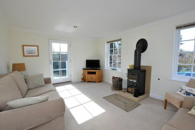 The sitting room has a cosy wood burner stove as a central feature.