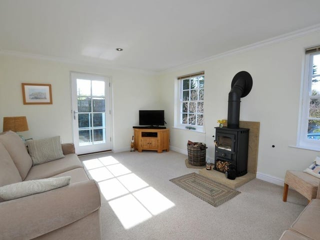 The sitting room has a cosy wood burner stove as a central feature.